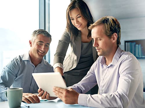 Businesswoman or manager in collaboration with colleagues reviewing project on digital tablet. Businesswoman or manager in collaboration with colleagues reviewing project on digital tablet.