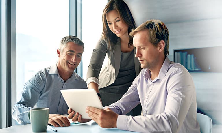 Businesswoman or manager in collaboration with colleagues reviewing project on digital tablet. Businesswoman or manager in collaboration with colleagues reviewing project on digital tablet.